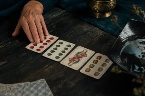 Traditionelle Spielkarten liegen in einer Reihe auf dunklem Holz